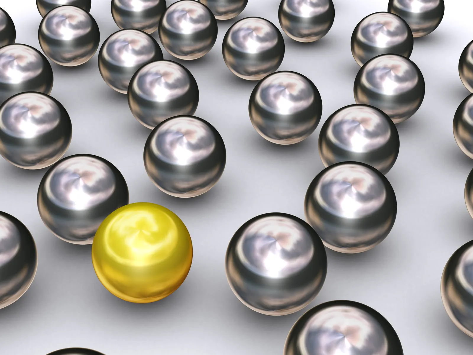 Single gold sphere among many shiny chrome spheres in a 3D render