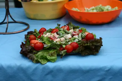Garden salad with red lettuce, cherry tomatoes and green beans on a blue tablecloth