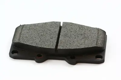 Black disc brake pad with metal backing plate on a white background